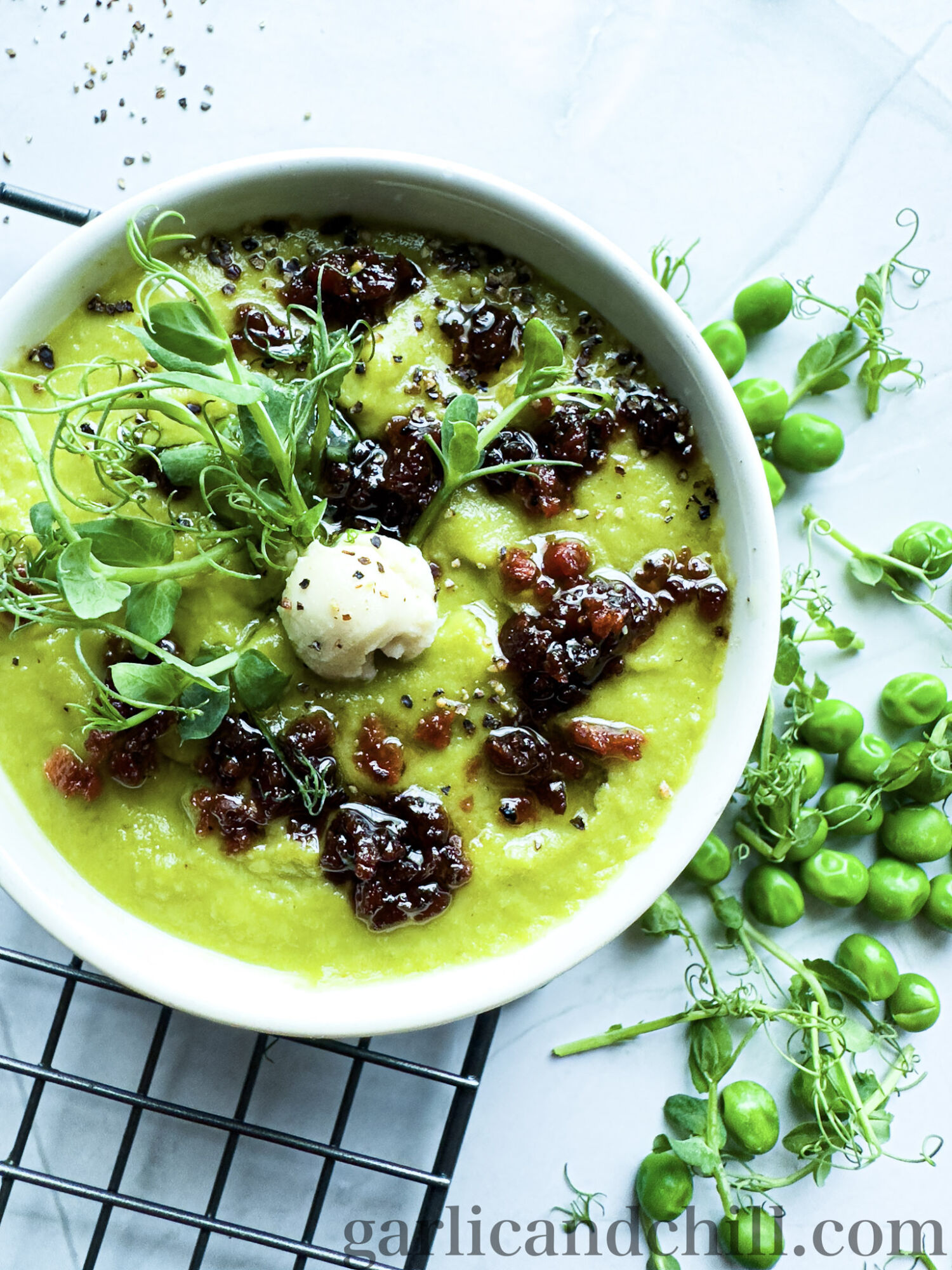 Vegan Fresh Pea Shoot Soup w/ Bac'n Oil in bowl with toppings